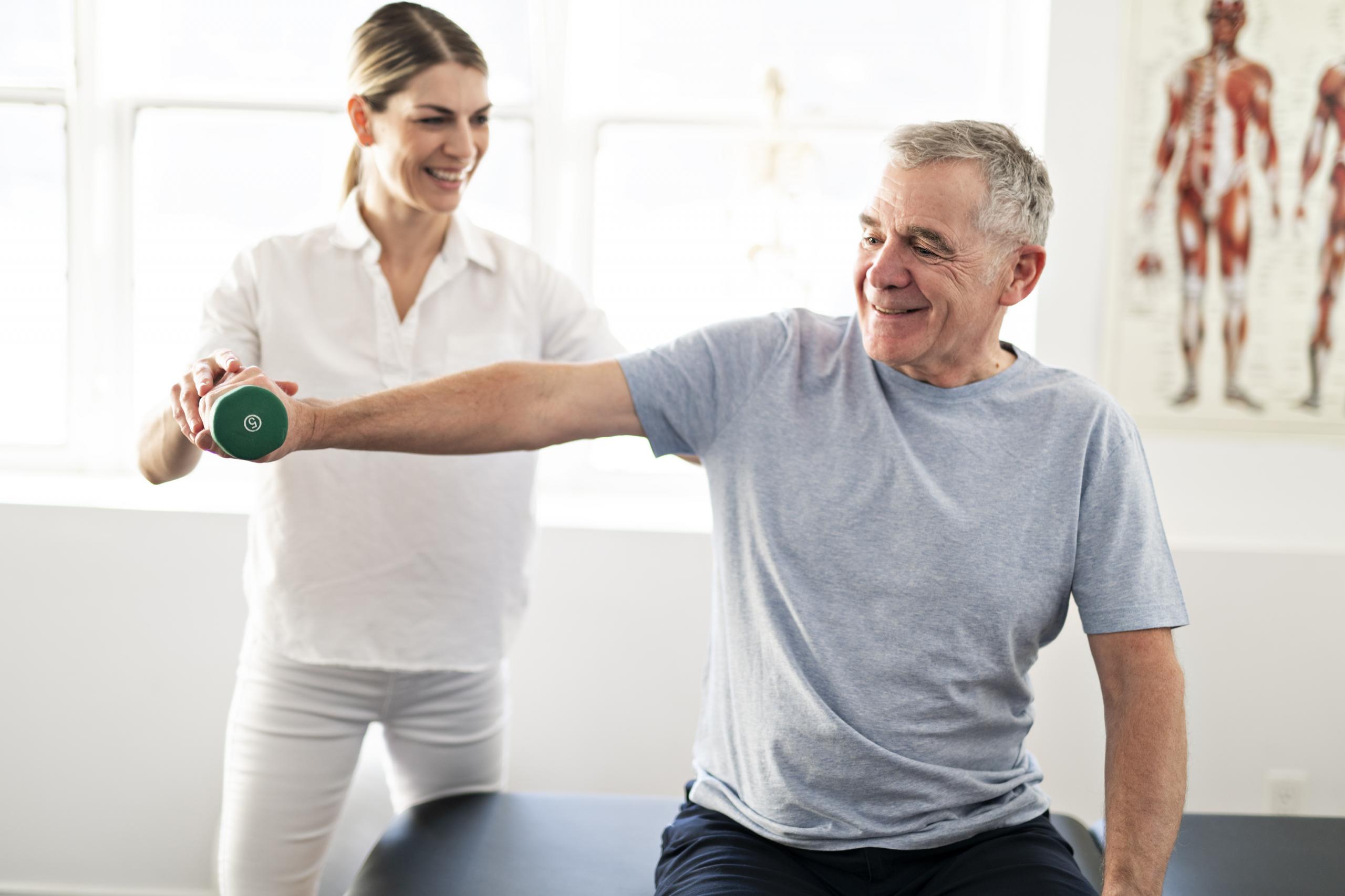 A Modern Rehabilitation Physiotherapy Worker With Senior Client