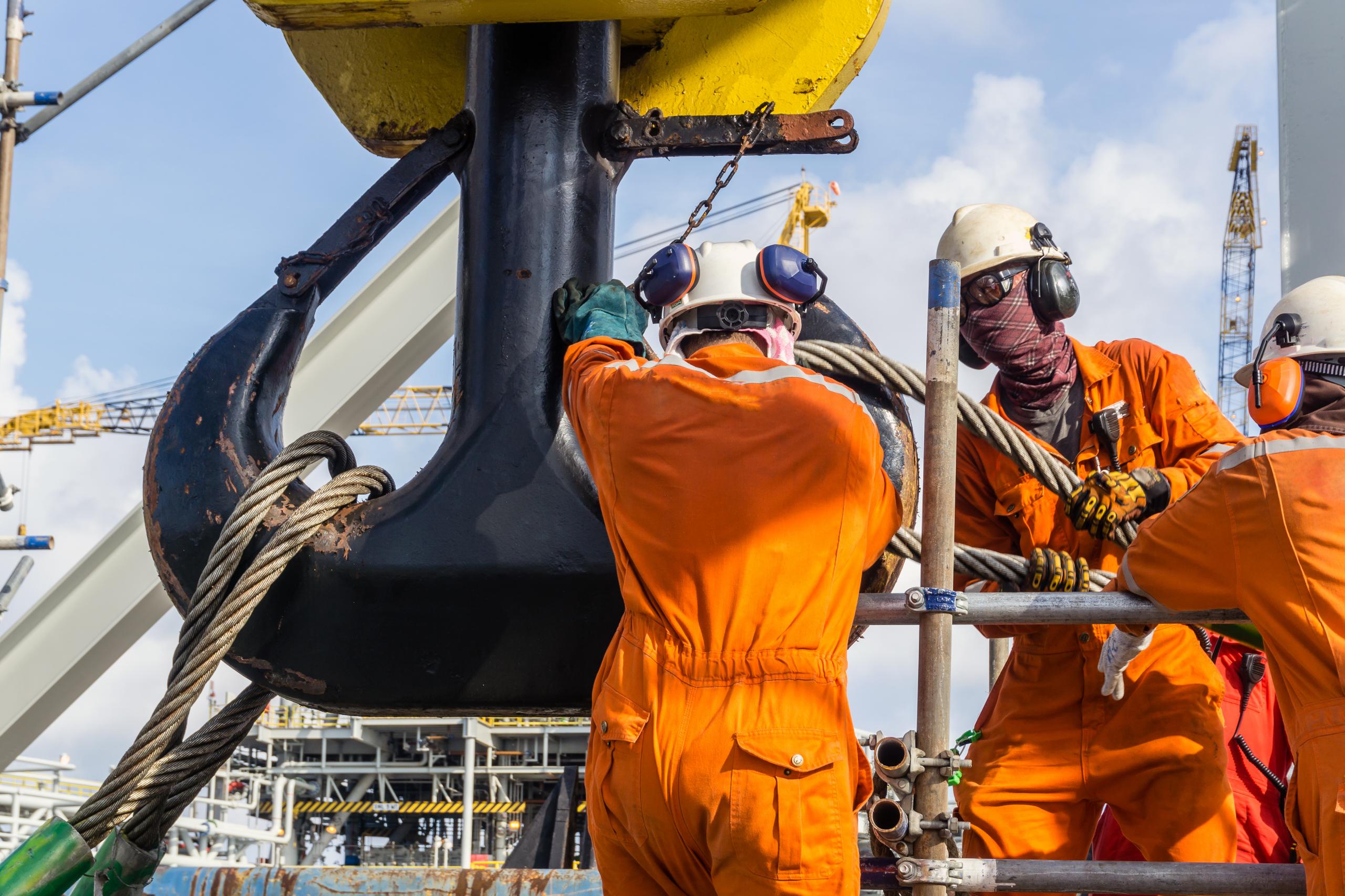 Offshore Workers Installing A Heavy Lifting Sling Onto A Crane H