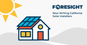 A sun rises over solar panels. Foresight now writes workers' comp for solar installers in California.